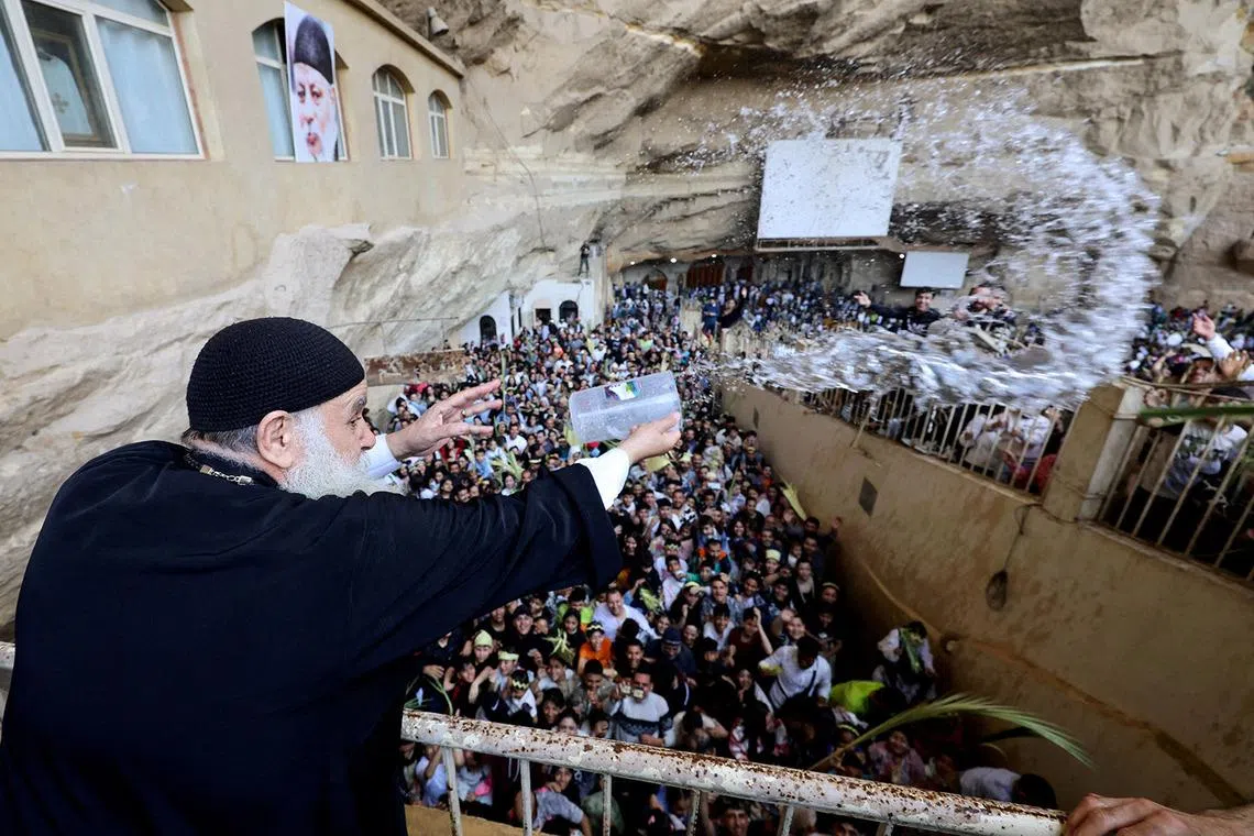 An Egyptian Coptic Orthodox Christian priest throws holy water during a Palm Sunday Mass at the Samaan el-Kharaz Monastery in the Mokattam Mountain area of Cairo, Egypt, April 5, 2026. REUTERS/Mohamed Abd El Ghany TPX IMAGES OF THE DAY