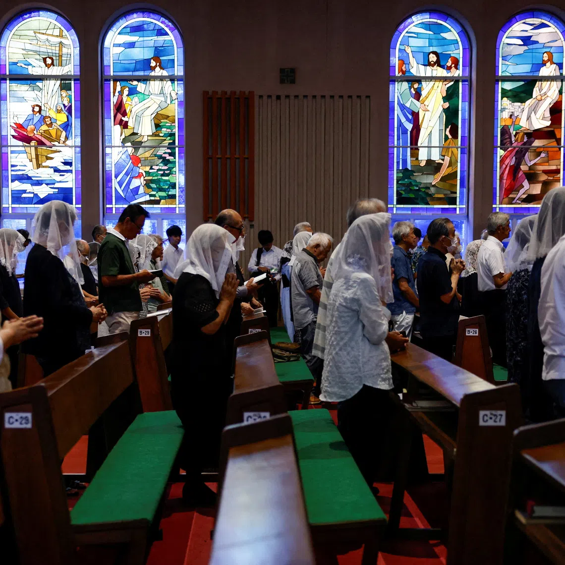 People praying for the victims of the 1945 atomic bombing during a mass at Urakami Cathedral in Nagasaki, Japan, on the 81st anniversary of the bombing of the city on Aug 9.