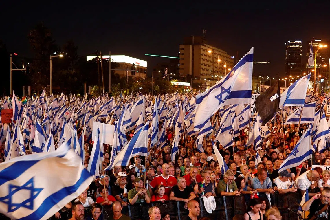 Tens of thousands of Israelis protest over the coalition government's planned judicial overhaul, in Tel Aviv.