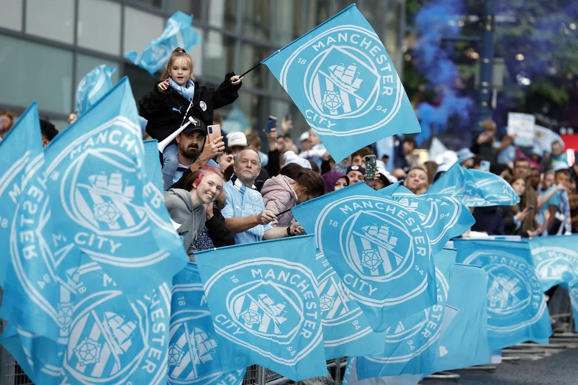 FILE PHOTO: Soccer Football - Premier League - Manchester City Victory Parade - Manchester, Britain - May 26, 2024 Manchester City fans with flags during the victory parade Action Images via Reuters/Jason Cairnduff/ File Photo