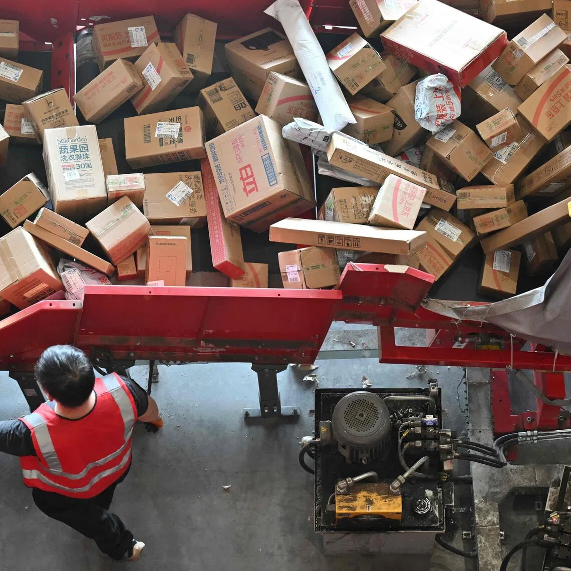A worker sorts packages at JD's warehouse during the double 11 festival or Singles's Day, China's massive annual shopping event in Beijing on November 11, 2025. (Photo by Adek BERRY / AFP)