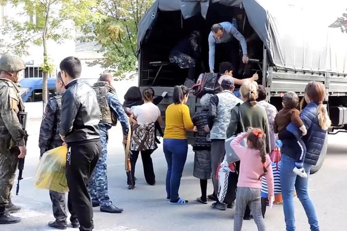 Russian peacekeepers evacuate civilians in the town of Askeran following the launch of a military operation by Azerbaijani forces in the region of Nagorno-Karabakh, a region inhabited by ethnic Armenians, in this still image from video published September 20, 2023. Russian Defence Ministry/Handout via REUTERS