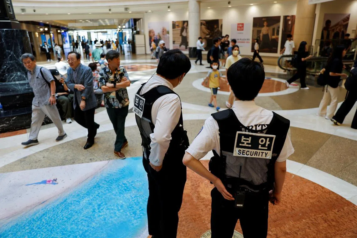 Security personnel stand guard at the scene where a random stabbing attack occurred, at a department store in Seongnam, South Korea, August 4, 2023. REUTERS/Kim Soo-hyeon