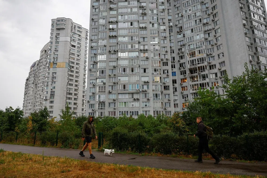 Residents walk in front of an apartment building damaged during a Russian drone strike, amid Russia's attack on Ukraine, in Kyiv, Ukraine July 28, 2025. REUTERS/Valentyn Ogirenko