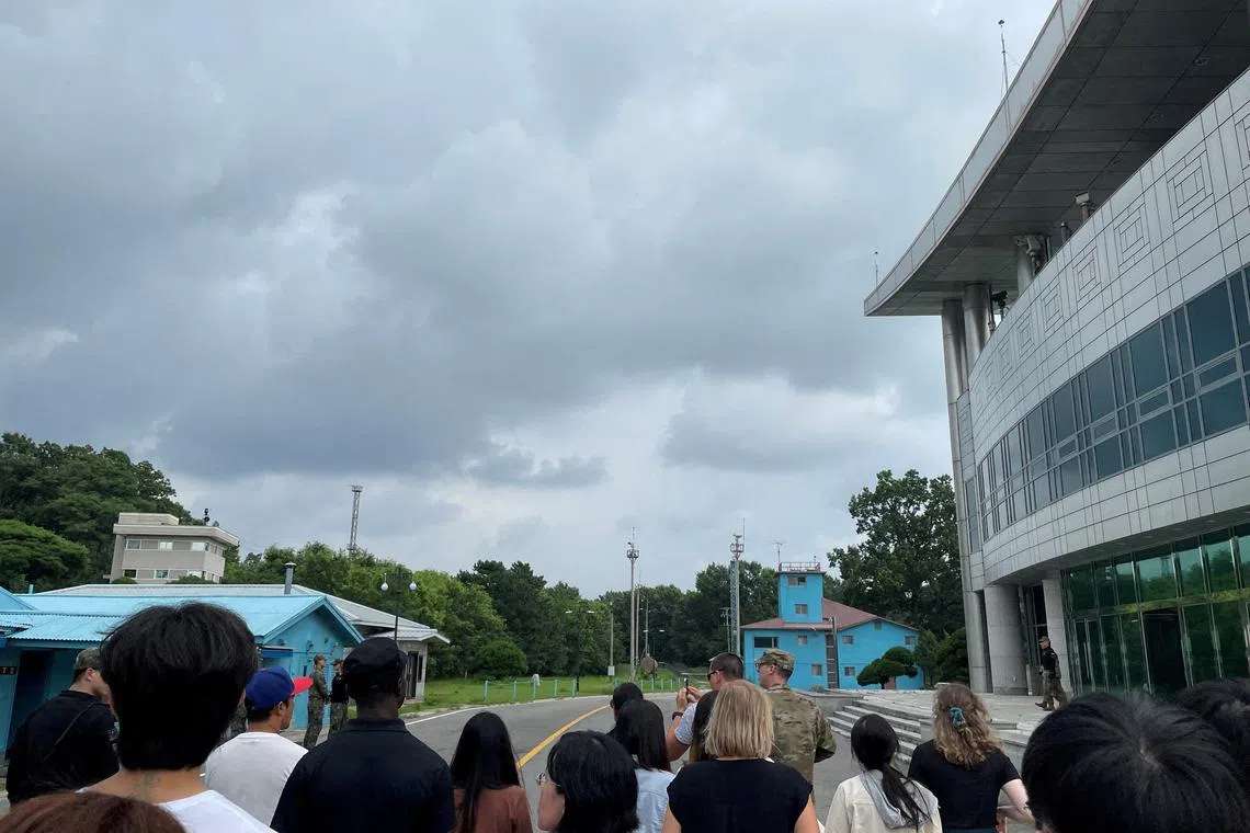 US Private Travis King (wearing a black shirt and black cap) is seen during a tour of the tightly controlled Joint Security Area at the truce village of Panmunjom, South Korea, on July 18, 2023.