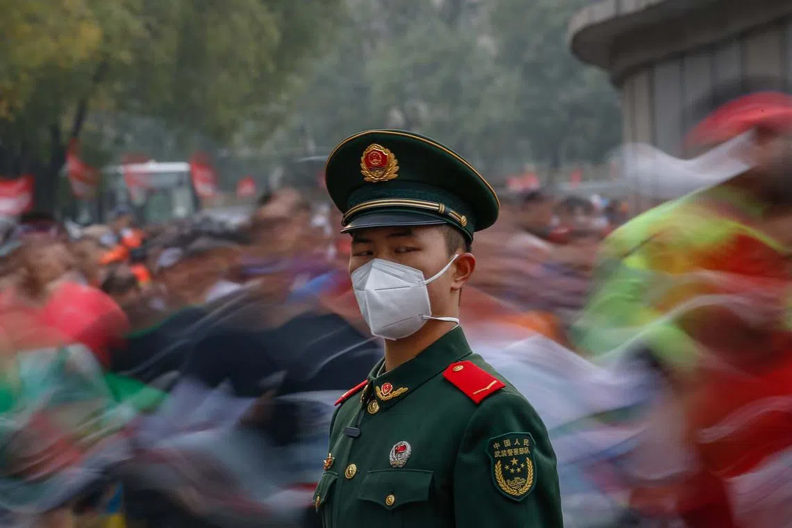 A soldier stands guard as runners compete during the Beijing Marathon in Beijing, China, Nov 6, 2022. The Beijing Marathon resumed after a two year hiatus following the COVID-19 pandemic. Participants were limited and were required to follow strict COVID-19 protocols before being able to join the race. 