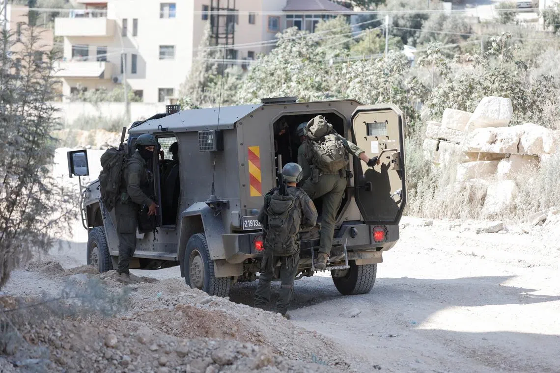 Israeli soldiers stand near a military vehicle during an Israeli raid in Nour Shams camp in Tulkarm, in the Israeli-occupied West Bank, August 29, 2024. REUTERS/Mohammed Torokman