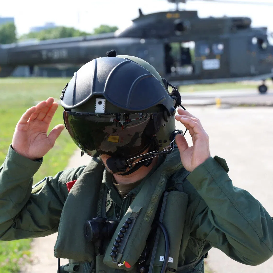 A Swiss pilot member of the NATO-led Kosovo Force (KFOR) adjusts his flight helmet at NATO?s headquarters in Pristina, Kosovo, June 20, 2023. REUTERS/Fatos Bytyci