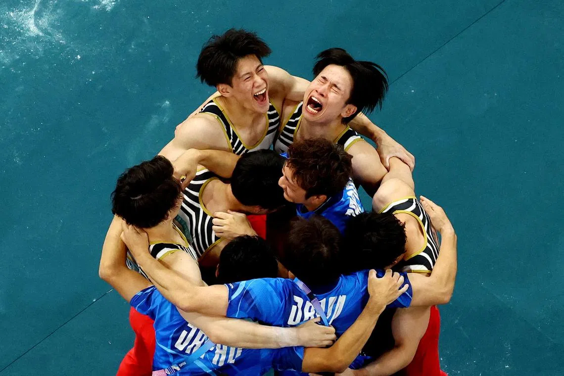 Paris 2024 Olympics - Artistic Gymnastics - Men's Team Final - Bercy Arena, Paris, France - July 29, 2024. Takaaki Sugino of Japan, Wataru Tanigawa of Japan, Shinnosuke Oka of Japan, Kazuma Kaya of Japan and Daiki Hashimoto of Japan celebrate with coaches after winning gold REUTERS/Athit Perawongmetha