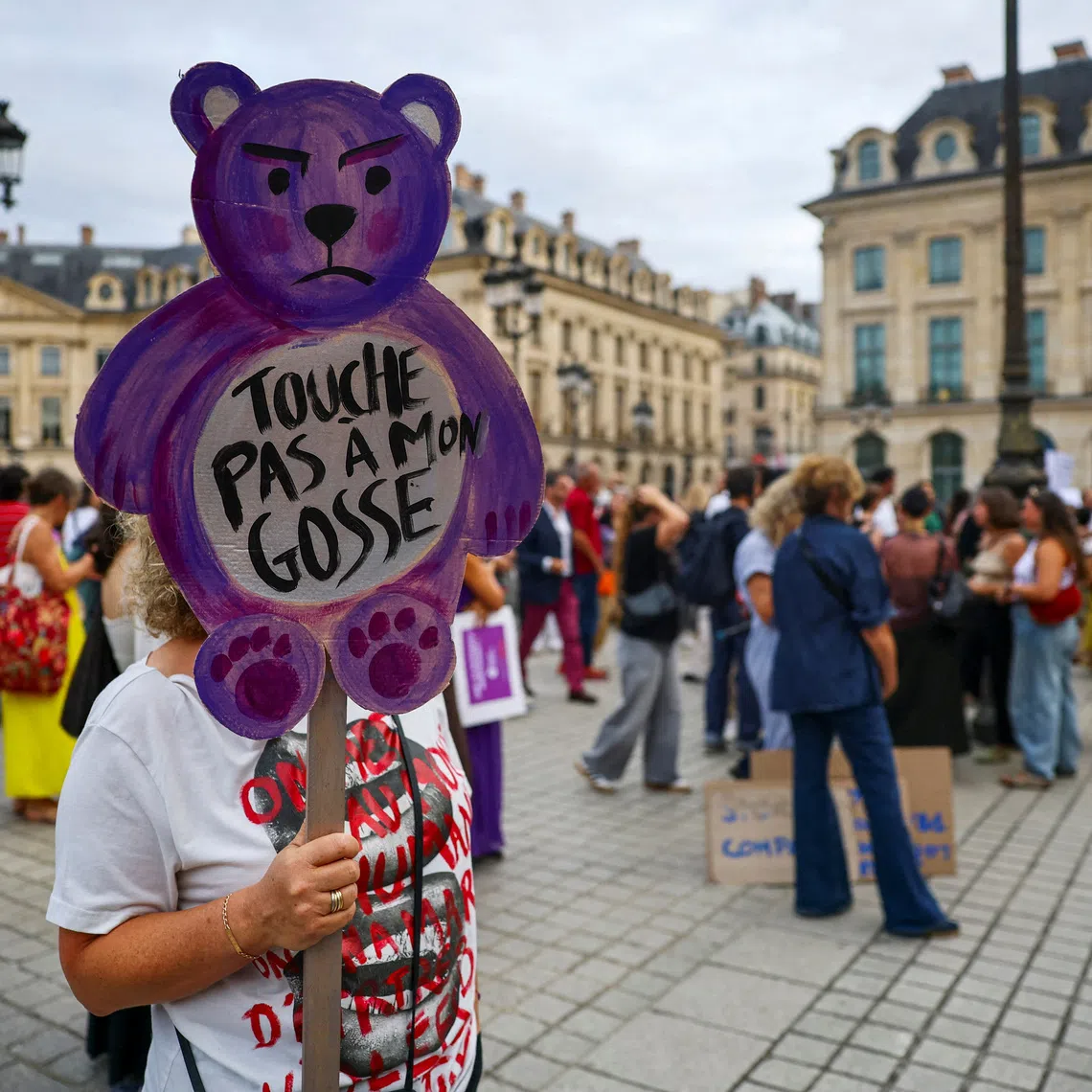 FILE PHOTO: A woman holds a placard which reads \"Don’t touch my child\" during a demonstration in support of victims of gender-based and sexual violence and to call for a \"comprehensive law\" against violence targeting women and children, in front of the Justice Ministry at Place Vendome in Paris, France, September 7, 2026. REUTERS/Sarah Meyssonnier/File Photo