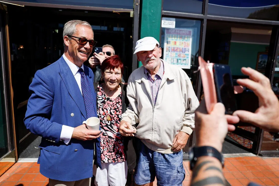 Britain's Reform UK Party Leader Nigel Farage poses with people, on the day of the general election, in Clacton-on-Sea, Britain, July 4, 2024. REUTERS/Clodagh Kilcoyne
