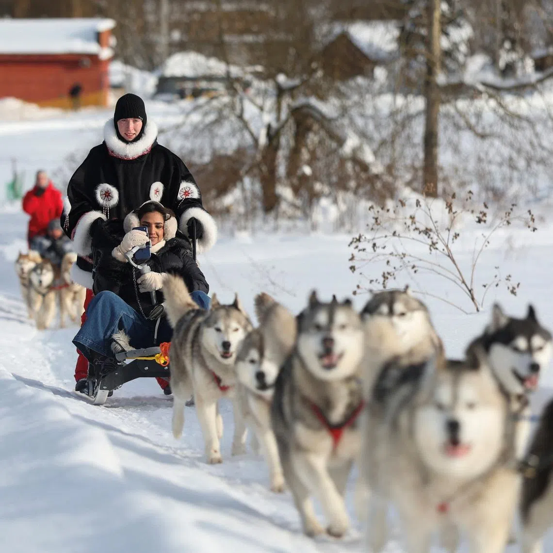 Fatma Albalushi, a tourist from Oman, rides in a sled pulled by huskies at Husky Land Park in the Moscow region, Russia February 10, 2026. REUTERS/Ramil Sitdikov