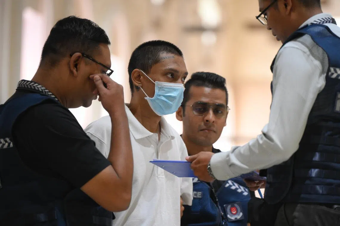 Basnayake Keith Spencer, who is accused of stabbing a priest at St Joseph’s Church, being taken back to the scene by police on Dec 6.