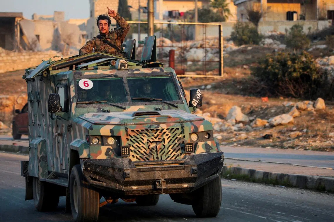 FILE PHOTO: A rebel led by the Islamist militant group Hayat Tahrir al-Sham stands in the back of a vehicle in al-Rashideen, Aleppo province, Syria November 29, 2024. REUTERS/Mahmoud Hasano/File Photo
