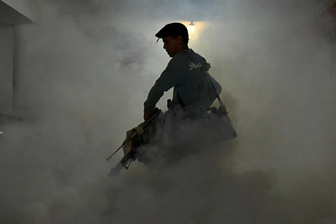 A health worker fumigates a garage with a fogging machine during a public health campaign to prevent mosquito-borne diseases, in Havana, Cuba, November 13, 2025. REUTERS/Norlys Perez