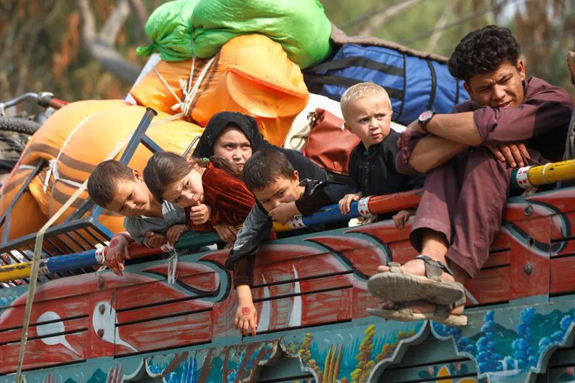 FILE PHOTO: Afghan refugee children sit on a truck loaded with belongings as they along with their families prepare to return home, after Pakistan gives the last warning to undocumented immigrants to leave, outside the United Nations High Commissioner for Refugees (UNHCR) repatriation centres in Azakhel town in Nowshera, Pakistan October 30, 2023. REUTERS/Fayaz Aziz/File photo