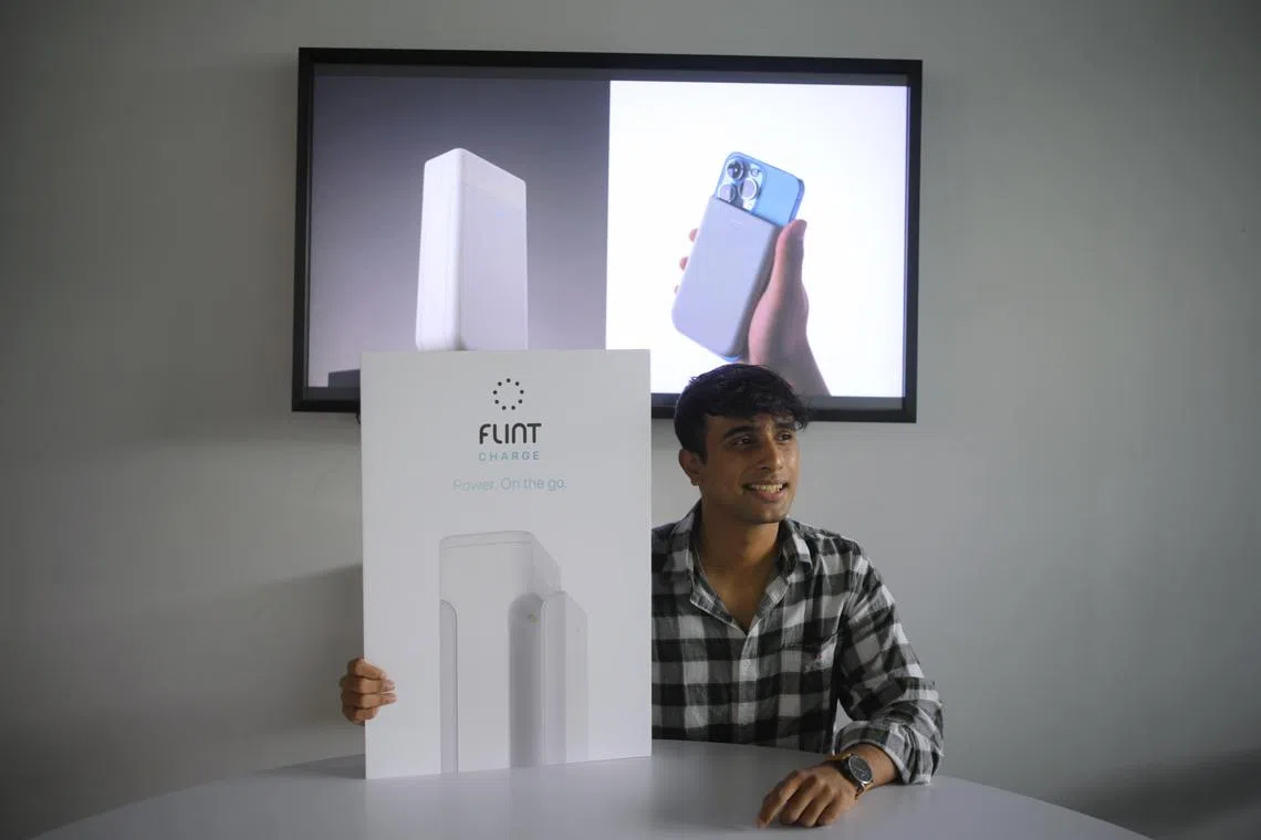 Nanyang Technological University (NTU) student Carlo Charles with pictures of his modular wireless power bank that has gained much crowdfunding support from Kickstarter that they had to pause orders, pictured on March 16, 2023.