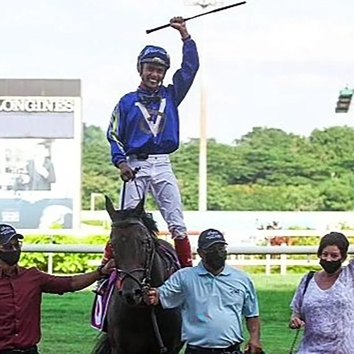 Jockey A'Isisuhairi Kasim celebrating his Group 1 Kranji Mile win on Minister with trainer Donna Logan at Kranji on May 22, 2021.

