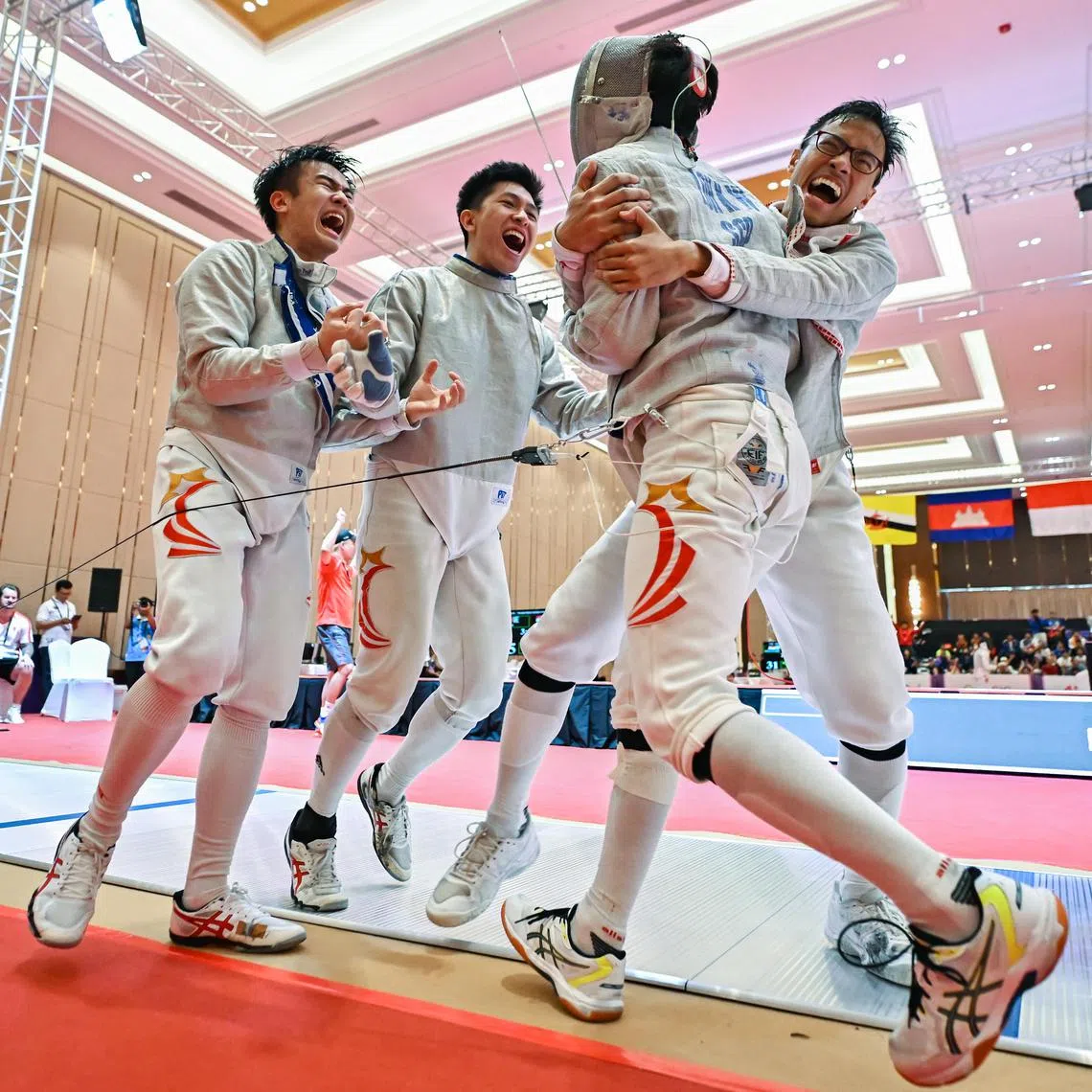 Fencers Dan Wei Zuo, Nicholas Loo and Jorelle See celebrating with Lucius Loh after reaching the men's sabre team final for the first time with the 45-41 semi-final win over Thailand. 
