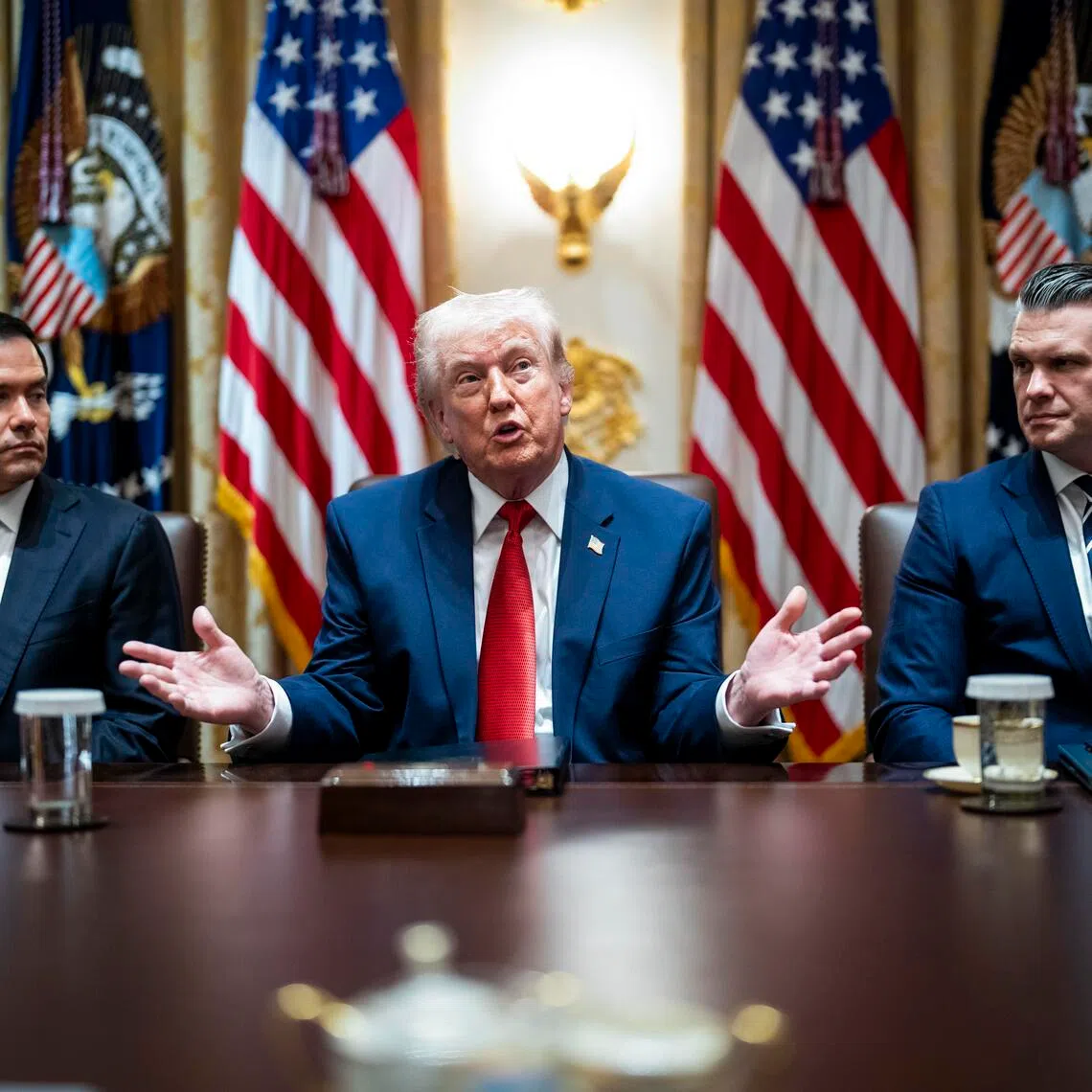 US President Donald Trump speaking during a Cabinet meeting on March 26, flanked by Secretary of State Marco Rubio (left) and Secretary of Defence Pete Hegseth.