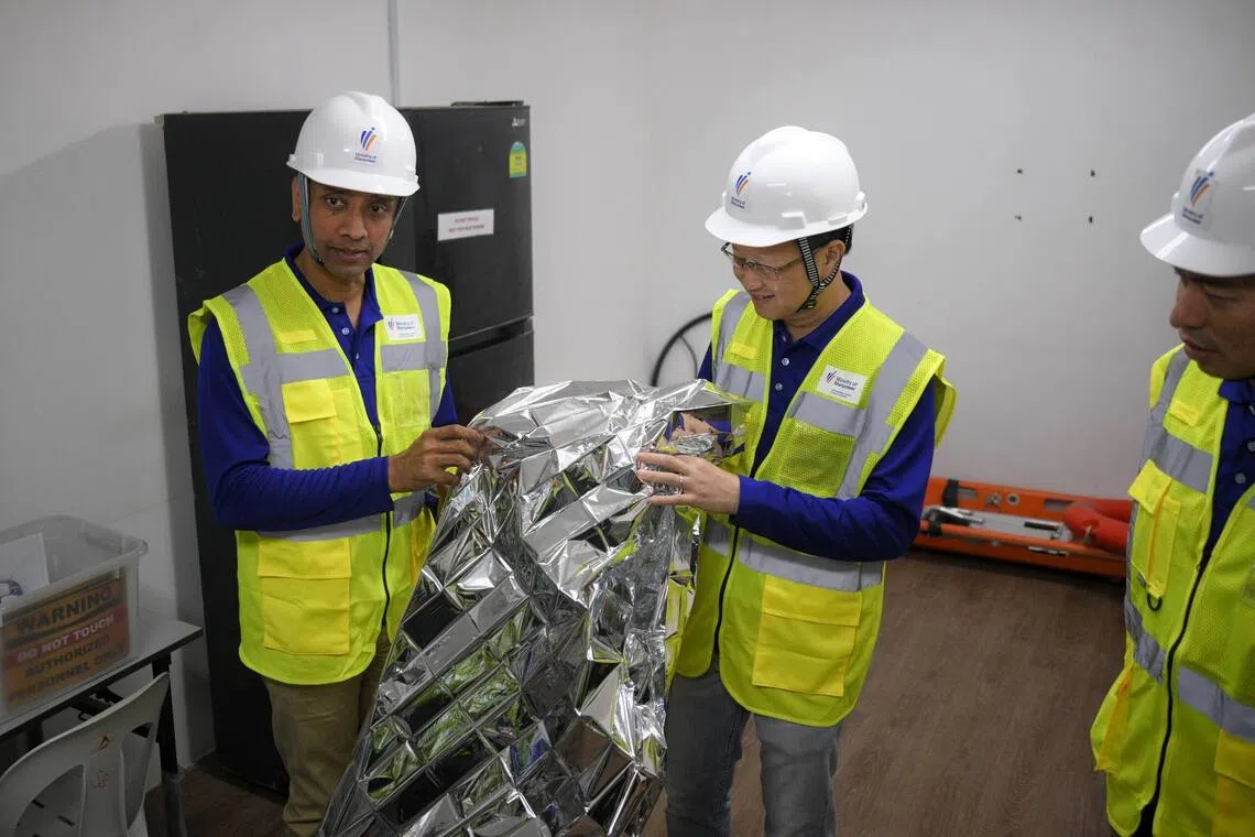 Minister of State for Manpower Dinesh Vasu Dash inspecting a thermal blanket during a visit to the construction site of the PSA Supply Chain Hub @ Tuas on Aug 28.