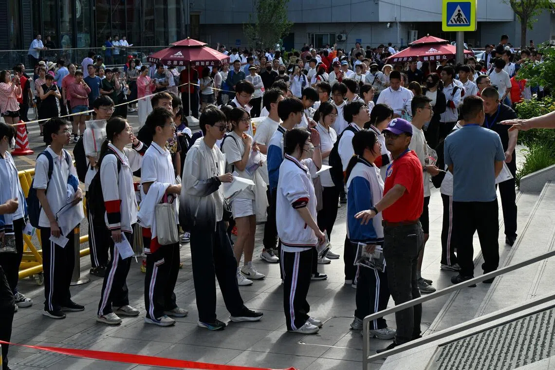 Students queue to enter a school during China's national college entrance exam, known as gaokao, outside a high school in Beijing on June 7, 2025.
