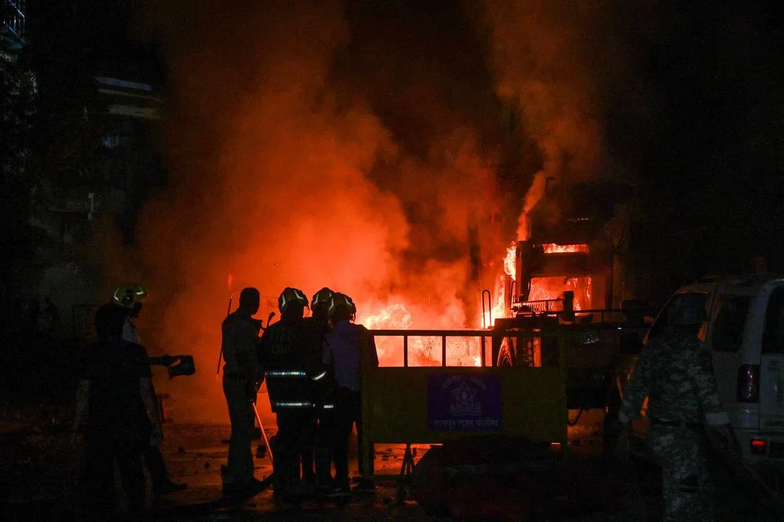 FILE PHOTO: Members of police stand as vehicles burn after clashes erupted due to demands over removal of the tomb of Mughal emperor Aurangzeb, in Nagpur, India, March 17, 2025. REUTERS/Stringer/File Photo