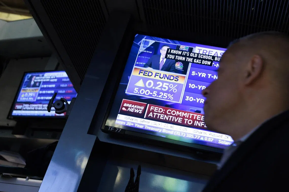 Traders work on the floor the New York Stock Exchange, during a news broadcast about the US Federal Reserve raising interest rates.