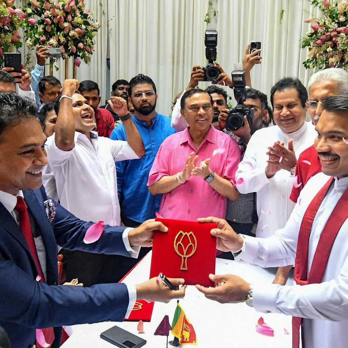 A scion of Sri Lanka’s Rajapaksa family, Namal Rajapaksa (2R) receives ticket from the Sri Lanka Podujana Peramuna (SLPP) party in Colombo on August 7, 2024, to contest the presidential election. Sri Lanka's ruling party nominated a scion of the controversial Rajapaksa family on August 7 to challenge the incumbent president in September 21 polls, the first since the country's unprecedented economic meltdown. (Photo by AFP)
