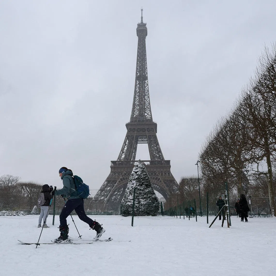 A woman skis on the snow-covered grounds near the Eiffel Tower in Paris as winter weather with snow and cold temperatures hits a part of the country, France, January 7, 2026. REUTERS/Gonzalo Fuentes