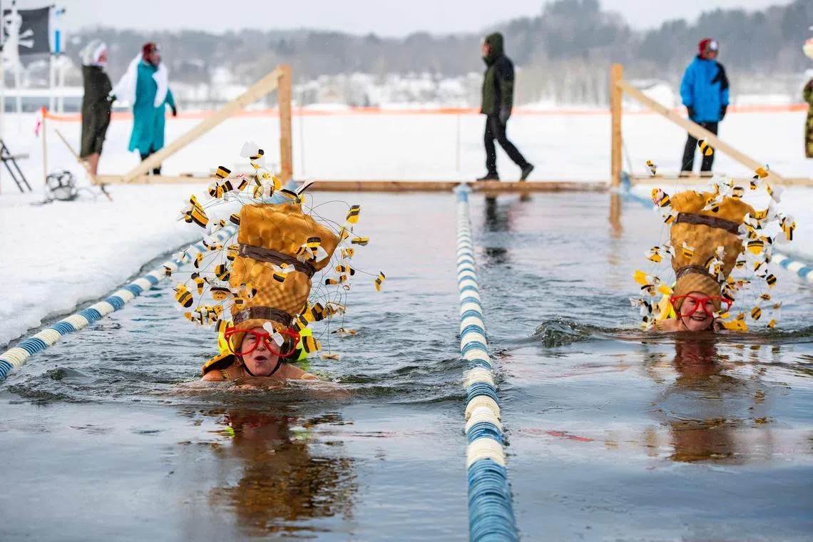 Swimmers take part in the 25 meter hat competition swim during the Memphremagog Winter Swimming Festival at lake Memphremagog in Newport, Vermont on February 21, 2025. The event brings together cold water swimmers of all ages, the youngest being 14 and the oldest 79, to swim Olympic-style heats in near-freezing water temperatures. (Photo by Joseph Prezioso / AFP)