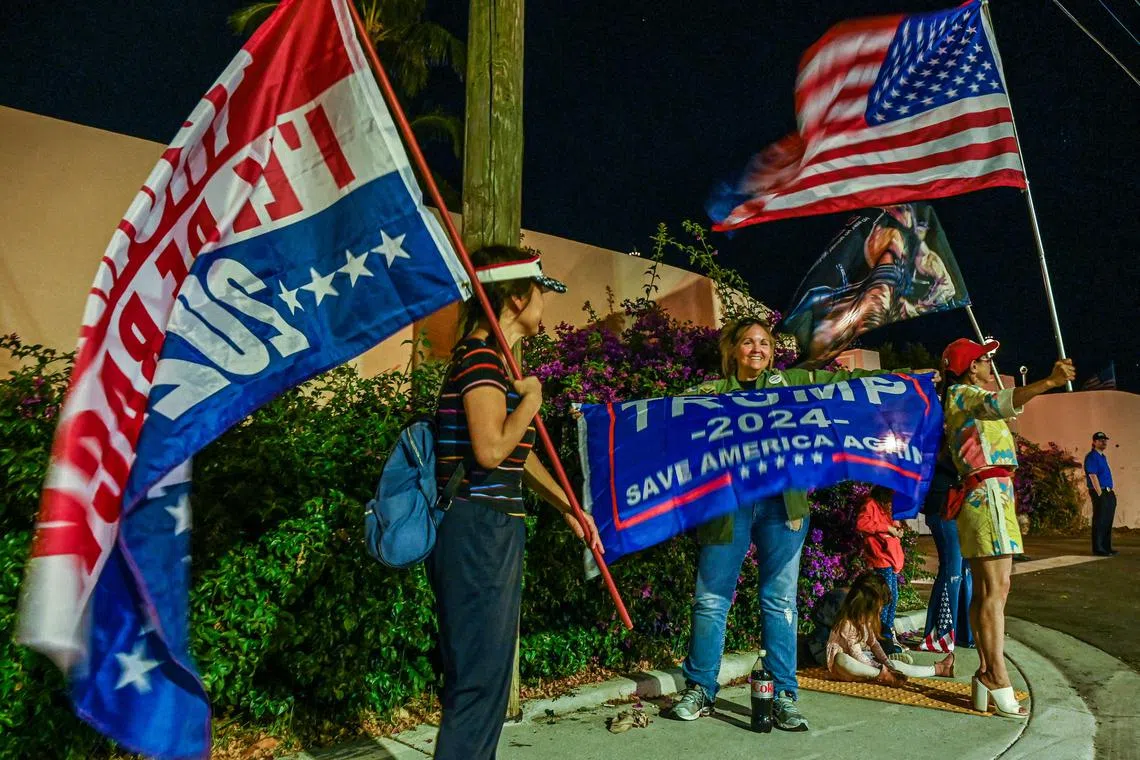 Supporters of former US President Donald Trump hold flags outside Trump's Mar-A-Lago residence in West Palm Beach on Nov 15, 2022. 