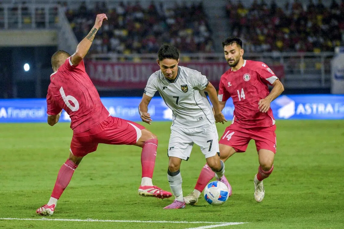 Indonesia's midfielder Marselino Ferdinand (C), one of the senior players in the SEA Games side, fights for the ball with Lebanon's defender Hussein Zein (L) and Lebanon's midfielder Gabriel Bitar (R) during a International friendly football match between Indonesia and Lebanon, at Gelora Bung Tomo Stadium in Surabaya, on September 8, 2025. (Photo by Juni KRISWANTO / AFP)