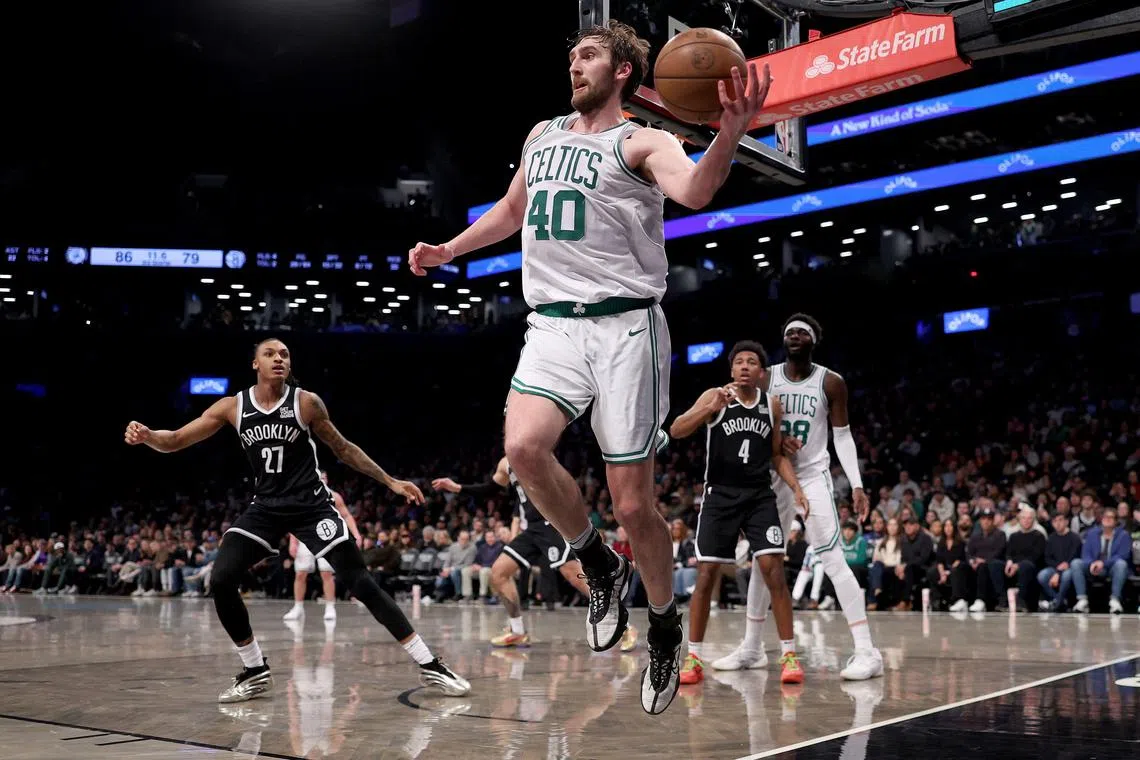 Luke Kornet of the Boston Celtics keeps the ball in bounds during an NBA game against the Brooklyn Nets at Barclays Centre.