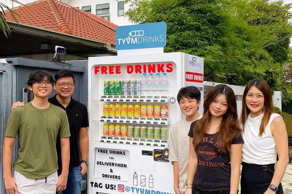 Mr Eric Chiam's family - Ethan Chiam, Mr Eric Chiam, Andre Chiam, Sophia Chiam, Dr Lisa Chen (from L tor R) - with the vending machine set up to offer delivery workers free drinks.