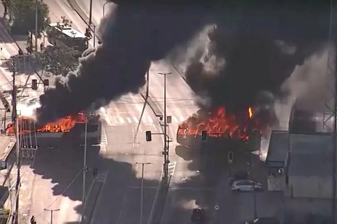 An aerial views shows buses in fire in the middle of roads, in Rio de Janeiro, Brazil, October 23, 2023, in this screen grab obtained from a video. TV GLOBO/via REUTERS