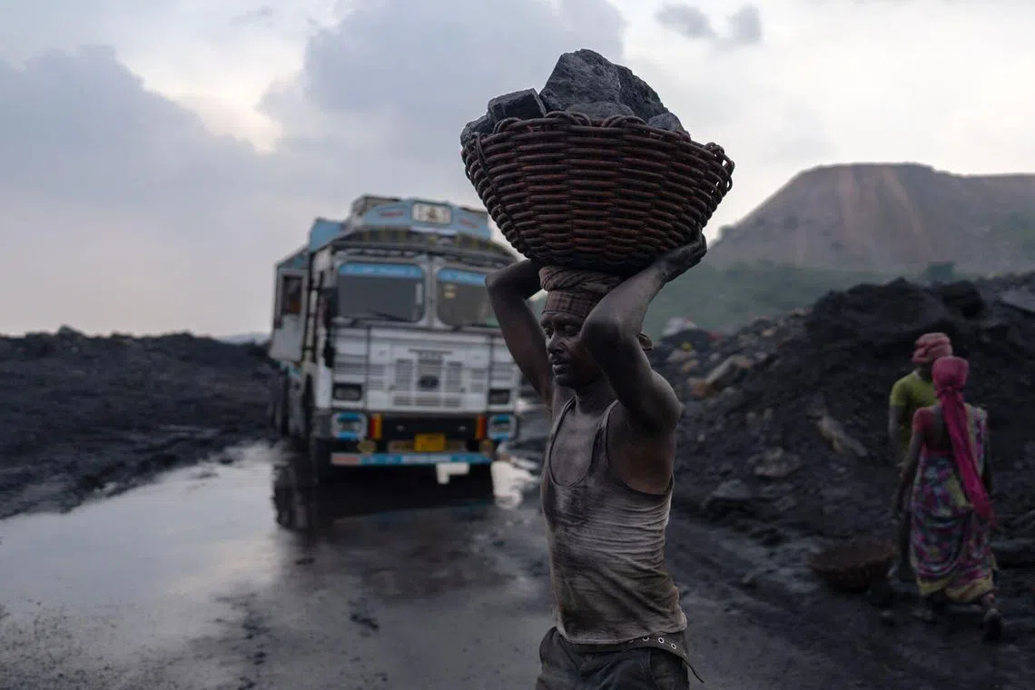 A worker carries coal on his heads at a mine in the outskirts of Dhanbad, Jharkhand, India, on Friday, Aug. 30, 2024. The Indian state of Jharkhand has passed a bill imposing mining taxes, according to people familiar with the matter, a move that's set to inflate the prices of minerals from coal to bauxite. Photographer: Anindito Mukherjee/Bloomberg
