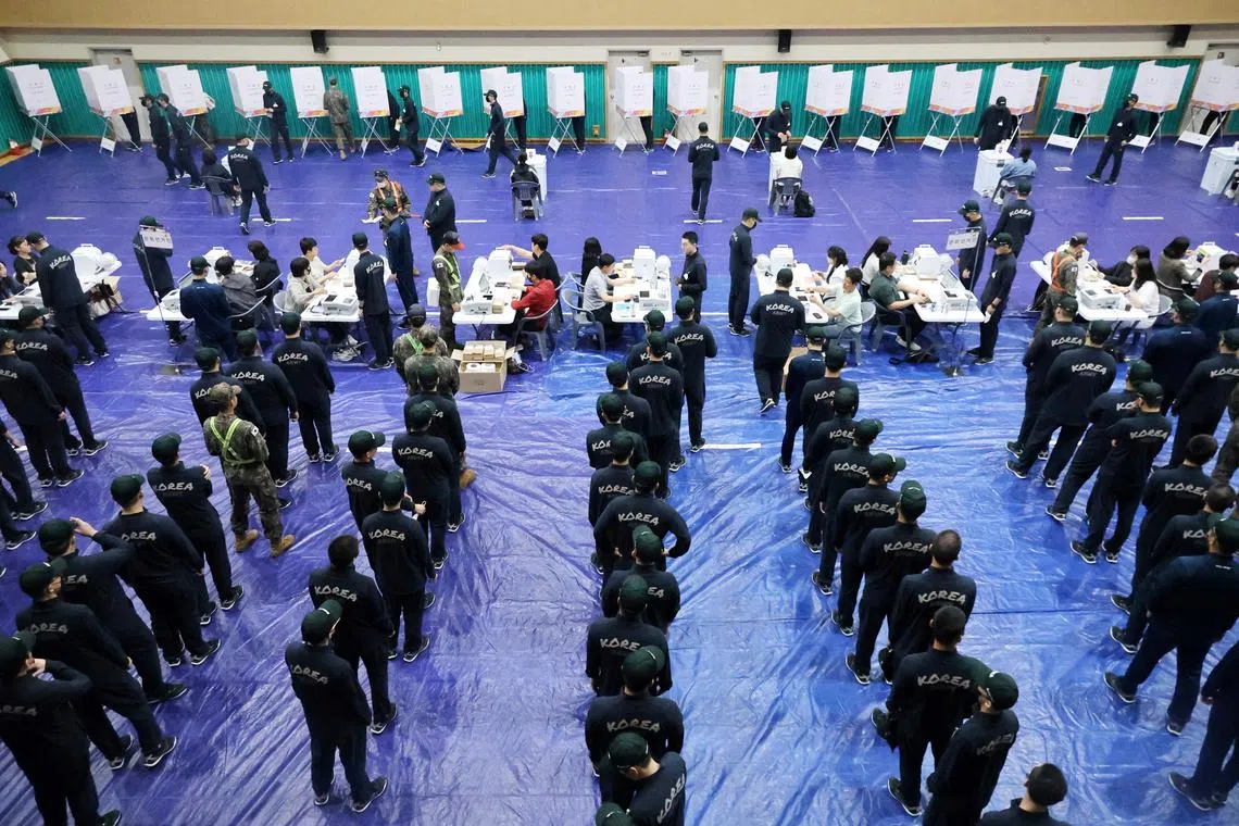 South Korean soldiers wait in a line to cast their early vote for the upcoming presidential election at a polling station in Nonsan on May 29.