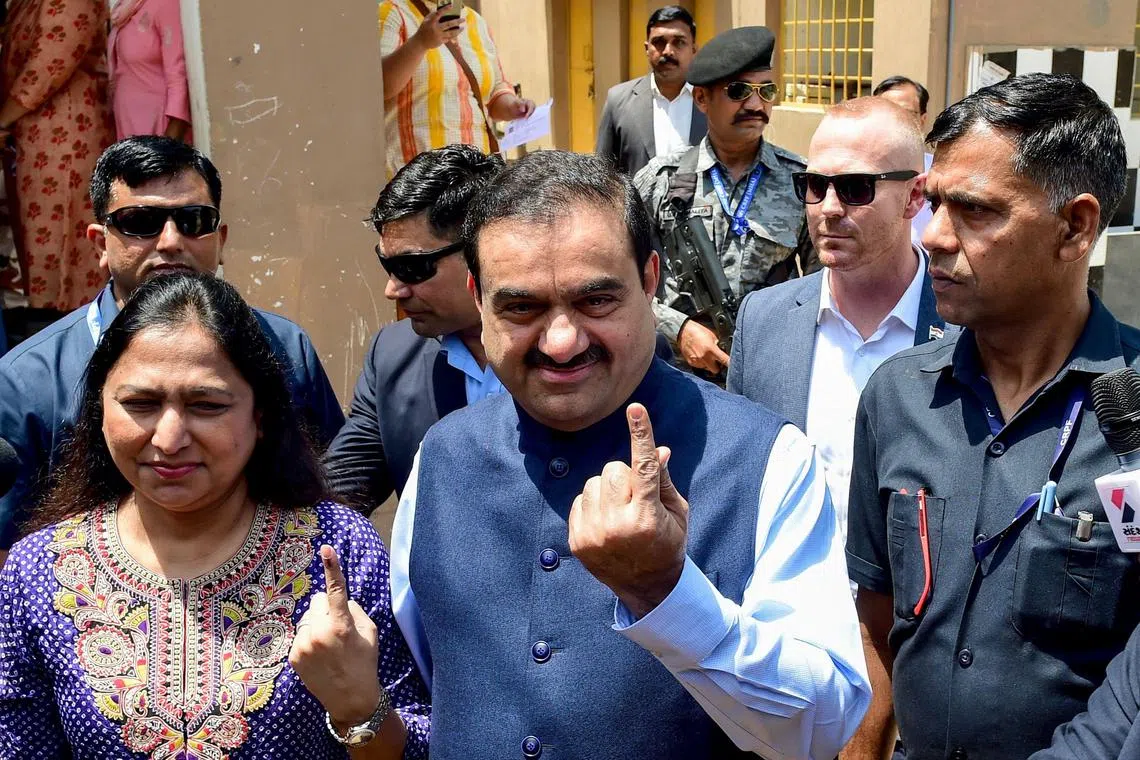 (FILES) Gautam Adani (4L), Chairperson of Indian conglomerate Adani Group and his wife Priti Adani (2L) show their inked finger after casting their ballot to vote in Ahmedabad on May 7, 2024, during the third phase of voting of India's general election. Billionaire Indian industrialist Gautam Adani has been charged with paying hundreds of millions of dollars of bribes and hiding the payments from investors, US prosecutors said on Wednesday.
With a business empire spanning coal, airports, cement and media, the chairman of Adani Group has been rocked in recent years by corporate fraud allegations and a stock crash.
The close acolyte of Hindu nationalist Prime Minister Narendra Modi, a fellow Gujarat native, is alleged to have agreed to pay more than $250 million in bribes to Indian officials for lucrative solar energy supply contracts. (Photo by Sam PANTHAKY / AFP)
