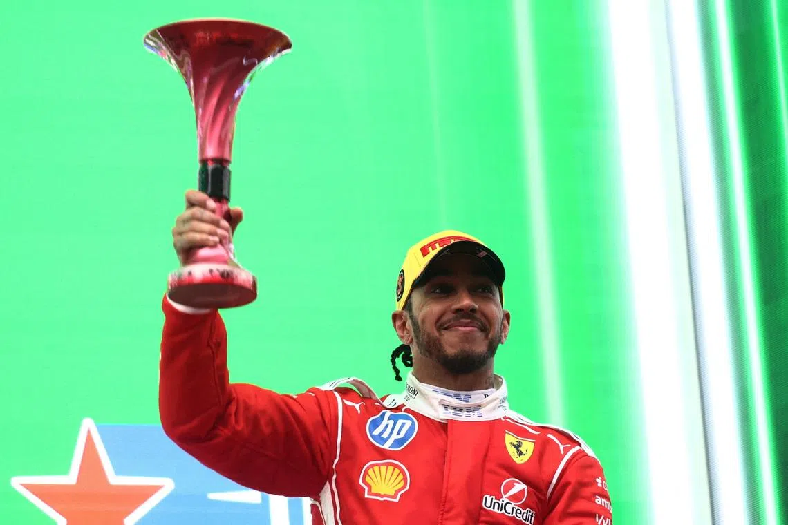 Formula One F1 - Chinese Grand Prix - Shanghai International Circuit, Shanghai, China - March 15, 2026 Ferrari's Lewis Hamilton celebrates with a trophy on the podium after finishing third place in the Chinese Grand Prix REUTERS/Jakub Porzycki
