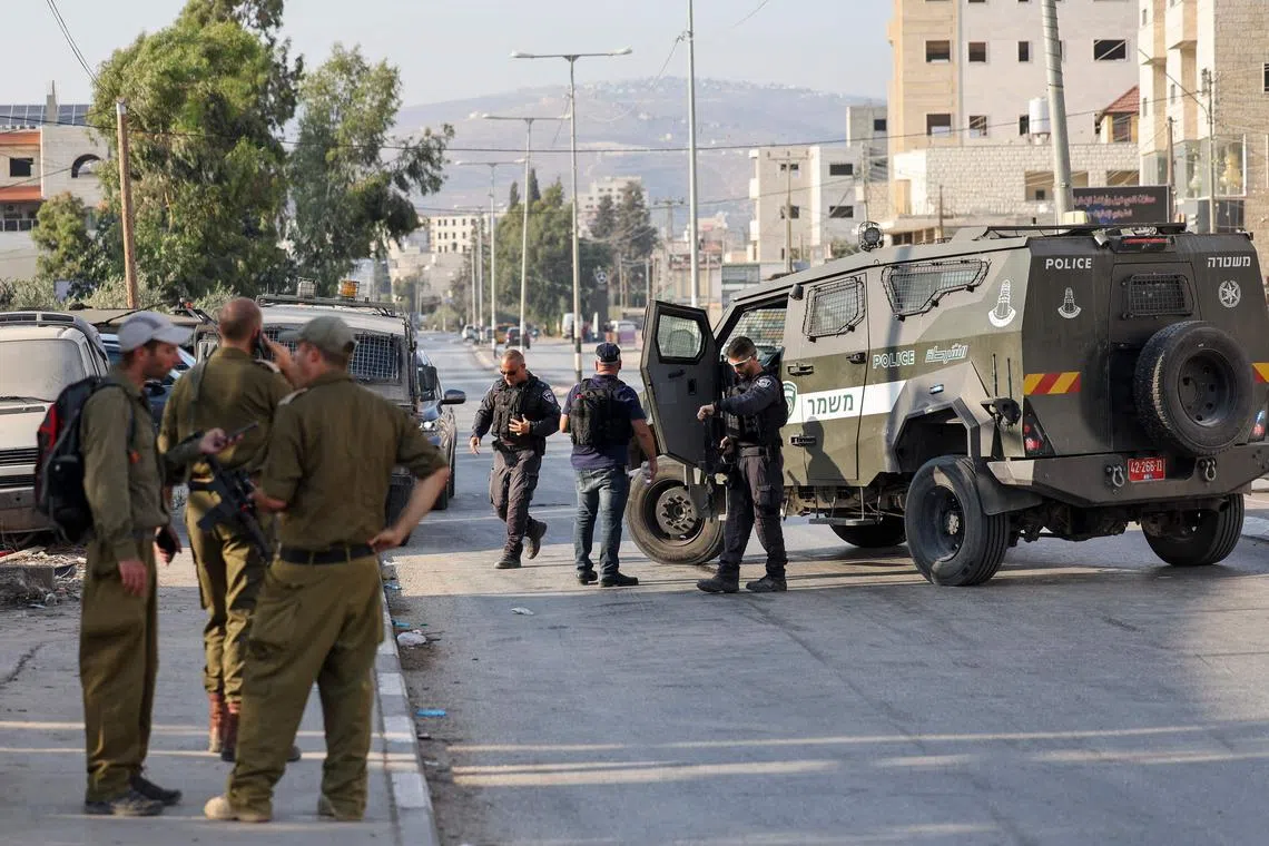Israeli security forces block a road following a reported attack in the town of Huwara in the occupied West Bank, on August 19, 2023. Two Israelis were killed today in a suspected shooting attack in the occupied West Bank, the army said. (Photo by AHMAD GHARABLI / AFP)