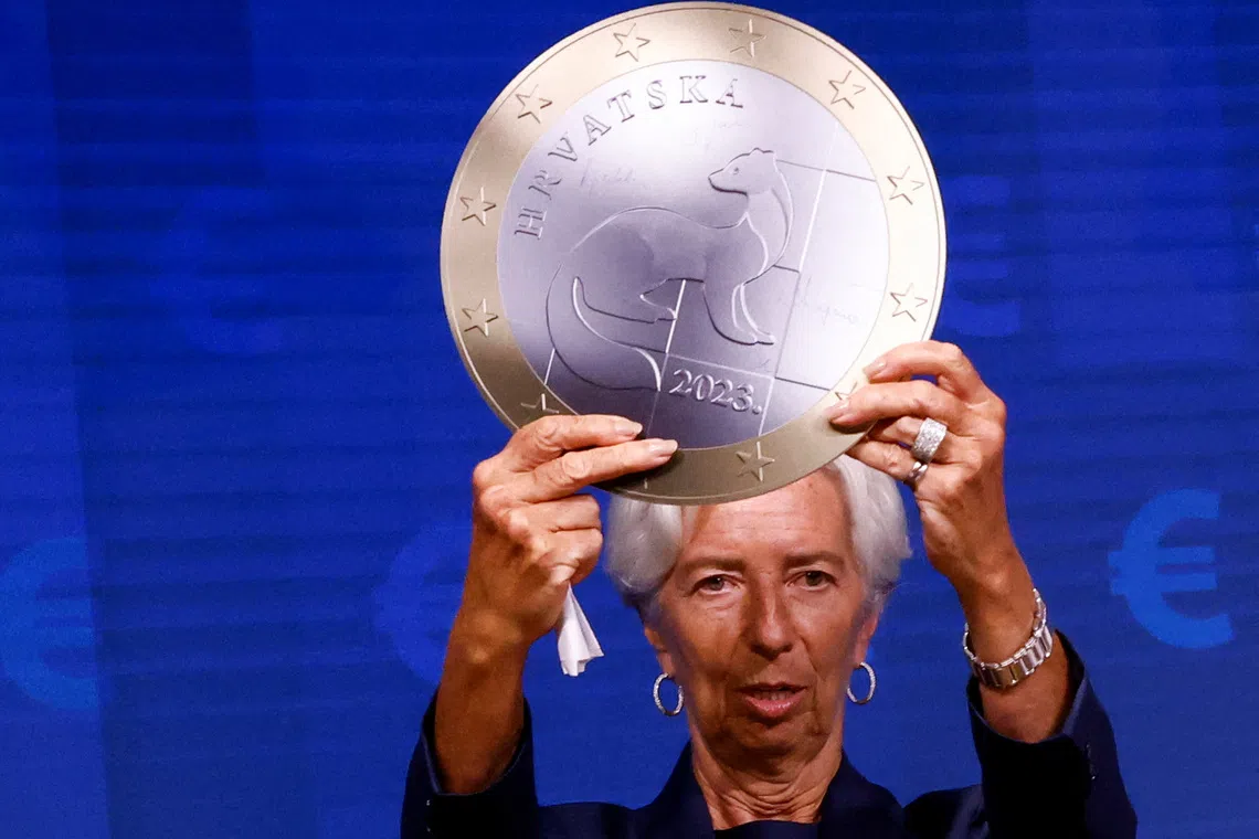 FILE PHOTO: President of European Central Bank Christine Lagarde poses with a model of a Euro coin after a signing ceremony on the adoption of the euro by Croatia in Brussels, Belgium July 12, 2022. REUTERS/Yves Herman/File Photo
