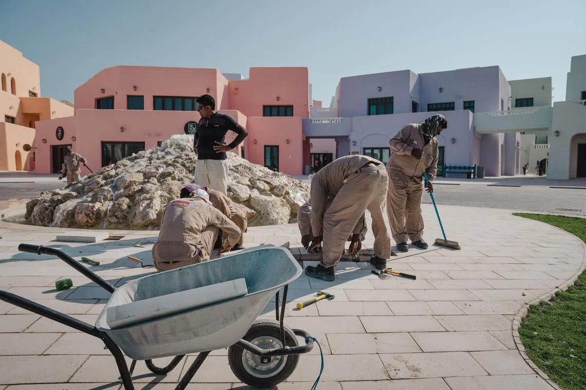 Workers clean a pedestrian area in Doha, Qatar, during the World Cup. 