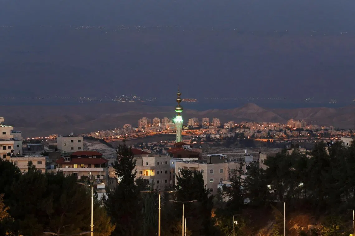 epa10712768 A view shows the Palestinian mosque of east Jerusalem neighborhood of Isawiyya, the urban Israeli settlement Ma'ale Adumim in the center, the Dead Sea and the Jordan in the background as seen from Jerusalem, 26 June 2023. Israel's Civil Administration Higher Planning Committee (HPC) approved on 26 June the promotion of 5,623 new housing units in the Israeli settlements in the occupied West Bank, including 1,428 in the Eli settlement.  EPA-EFE/ATEF SAFADI