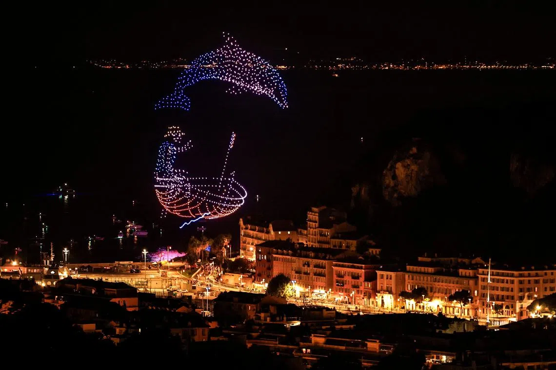 TOPSHOT - This photograph shows a drone light show to celebrate the arrival of the 111th edition of the Tour de France cycling race in Nice, southeastern France, on July 20, 2024. The final stage of the 2024 Tour de France takes place in the french riviera city of Niceon July 21, 2024, due to the Olympics in the French capital. (Photo by Valery HACHE / AFP)