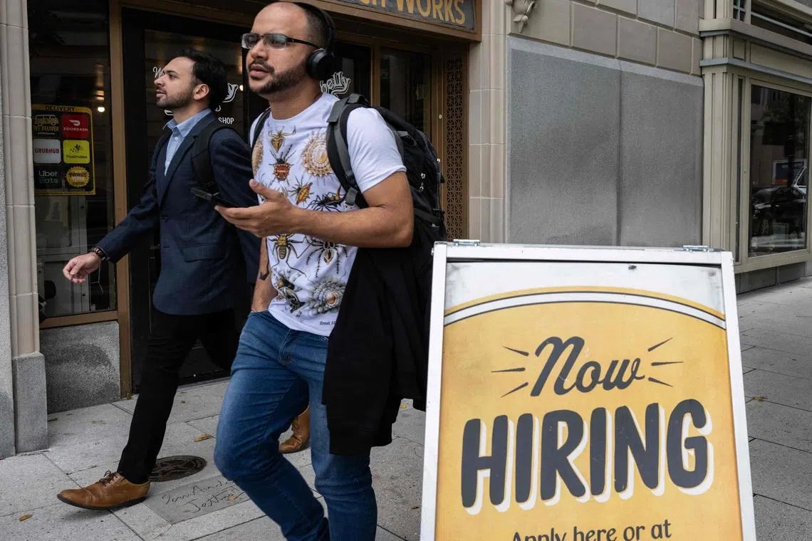 People walk past a restaurant, with a hiring sign outside, in Washington, DC on October 5, 2023. Private payrolls rose 89,000 last month after climbing 180,000 in August, according to figures published Wednesday by the ADP Research Institute, the fewest number of jobs since the start of 2021 in September. (Photo by ANDREW CABALLERO-REYNOLDS / AFP)