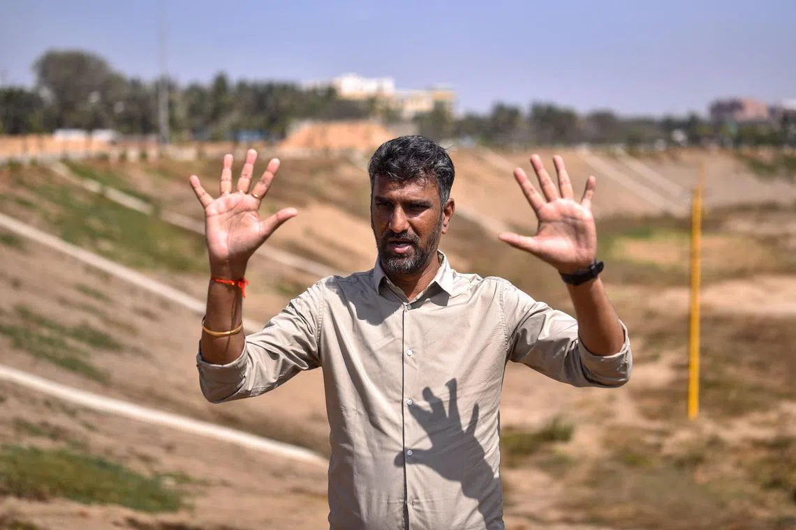 This photograph taken on January 29, 2024 shows mechanical engineer Anand Malligavad, known as "lake man" for his campaign to bring scores of lakes back to life, during an interview with AFP near the arid Doddathogur lake in Bengaluru. In the rush to modernise, the Bengaluru city dubbed as being India's Silicon Valley had forgotten the centuries-old structures it depended upon to survive, with the number of lakes shrinking by more than three-quarters. (Photo by Idrees MOHAMMED / AFP) / To go with 'INDIA-ENVIRONMENT-POLLUTION-WATER’ FOCUS by Aishwarya KUMAR