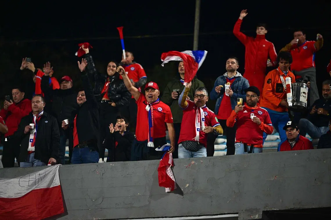 Chilean fans cheering before the start of the World Cup South American qualifier between Uruguay and Chile at the Centenario stadium in Montevideo, on Sept 8. Uruguayan football authorities admitted they had erred after high prices left thousands of seats empty.
