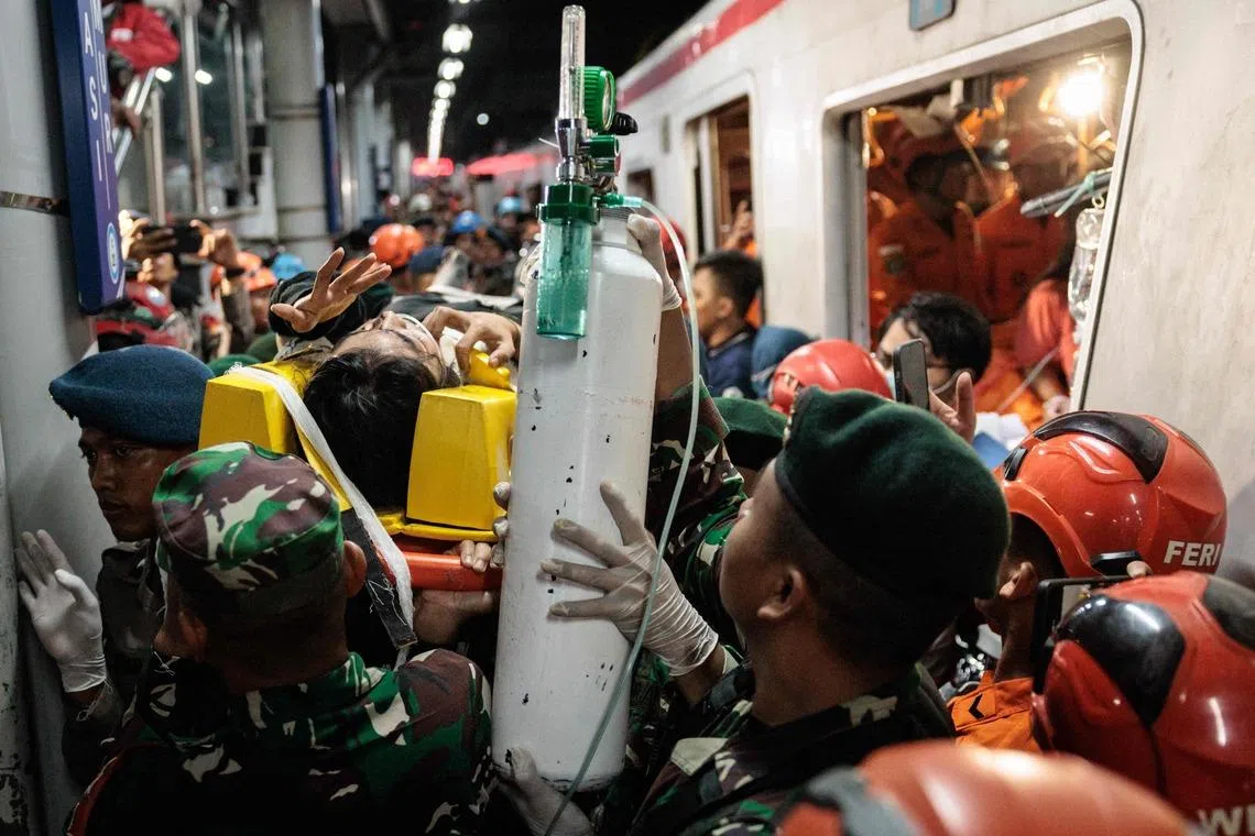 Rescuers carrying out a survivor that was trapped inside a carriage.