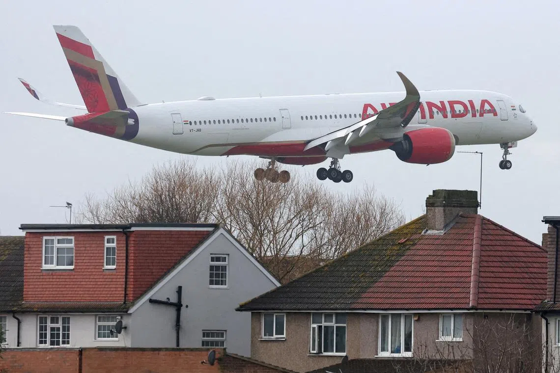 FILE PHOTO: An Air India passenger plane flies near houses as it makes its landing approach to Heathrow Airport in west London, Britain, January 28, 2025.  REUTERS/Toby Melville/File Photo